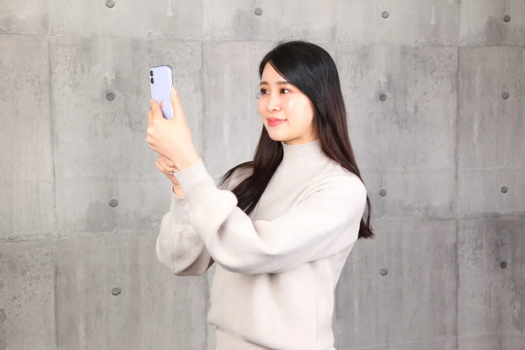 スマートフォンで自撮りをする女性